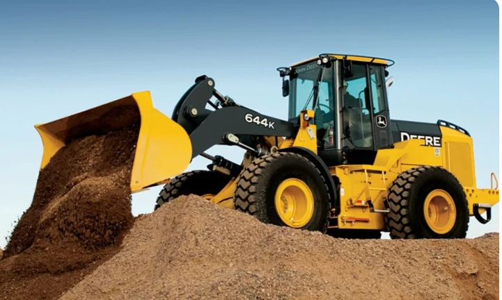 Pá carregadeira amarela movimentando terra com a concha