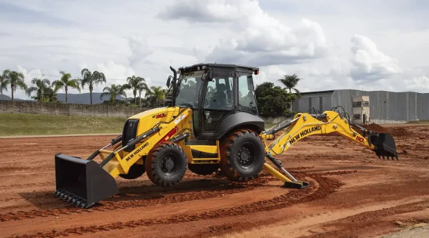 Retroescavadeira amarela em operação no terreno de uma obra
